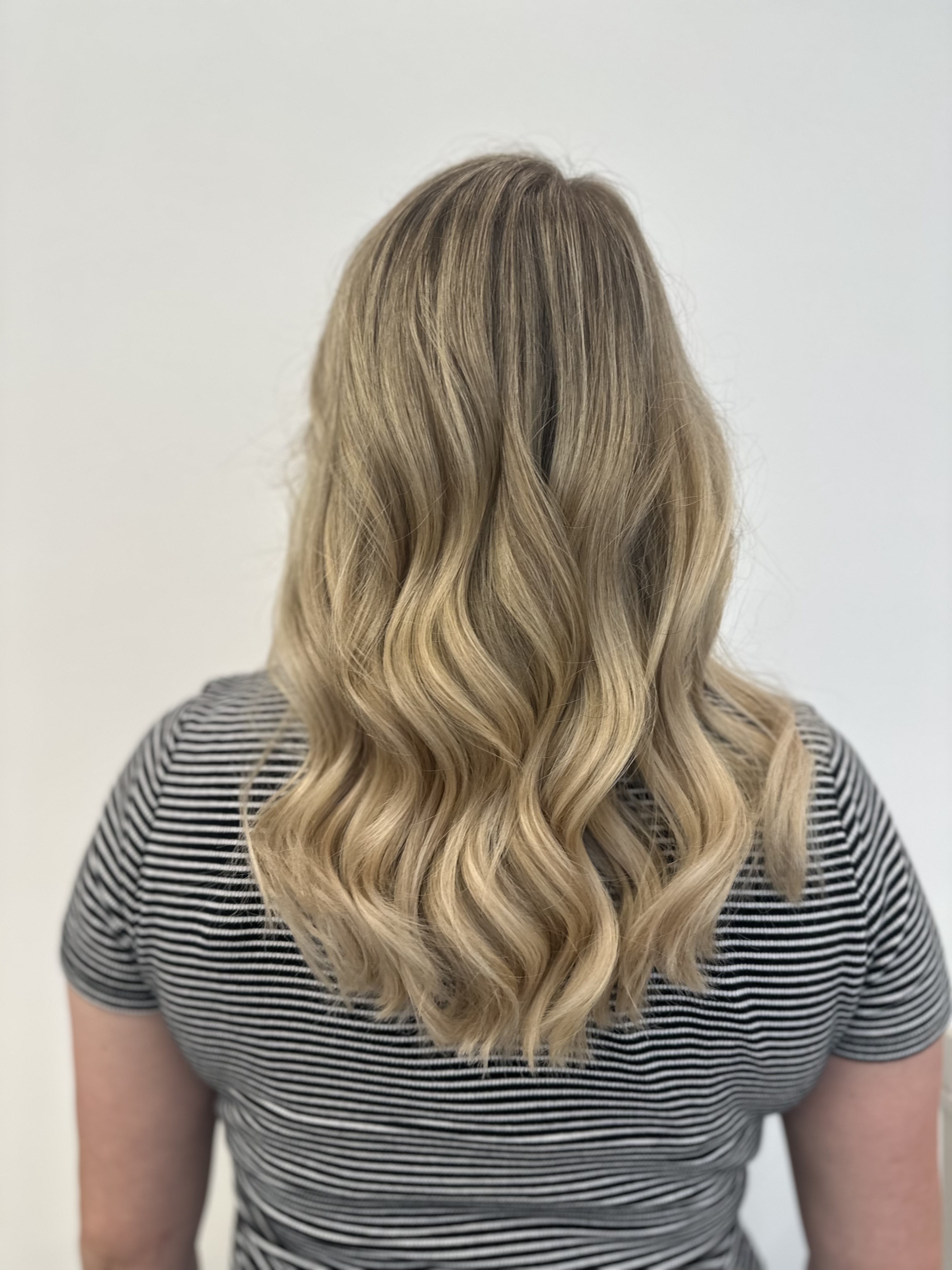 Lange, gewellte Haare in einem hellen Blondton – professionell gestylt bei Hair Flair in Eberstalzell.